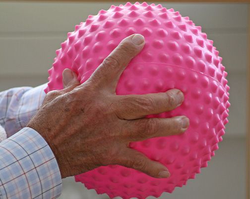 Ein Mann hält einen rosa Ball in der Hand.